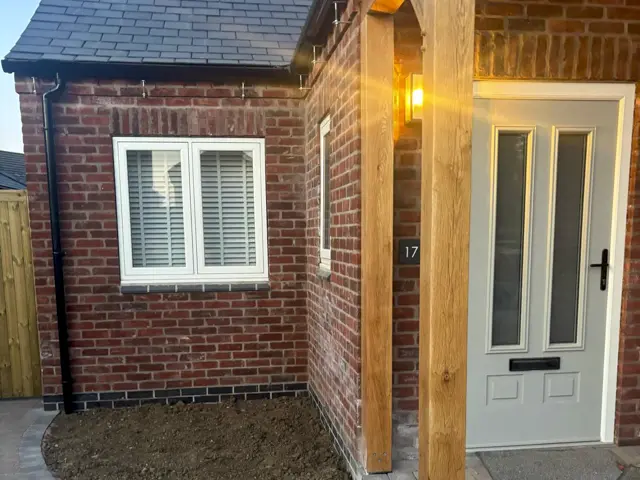 Brick home extension with front porch and doorway